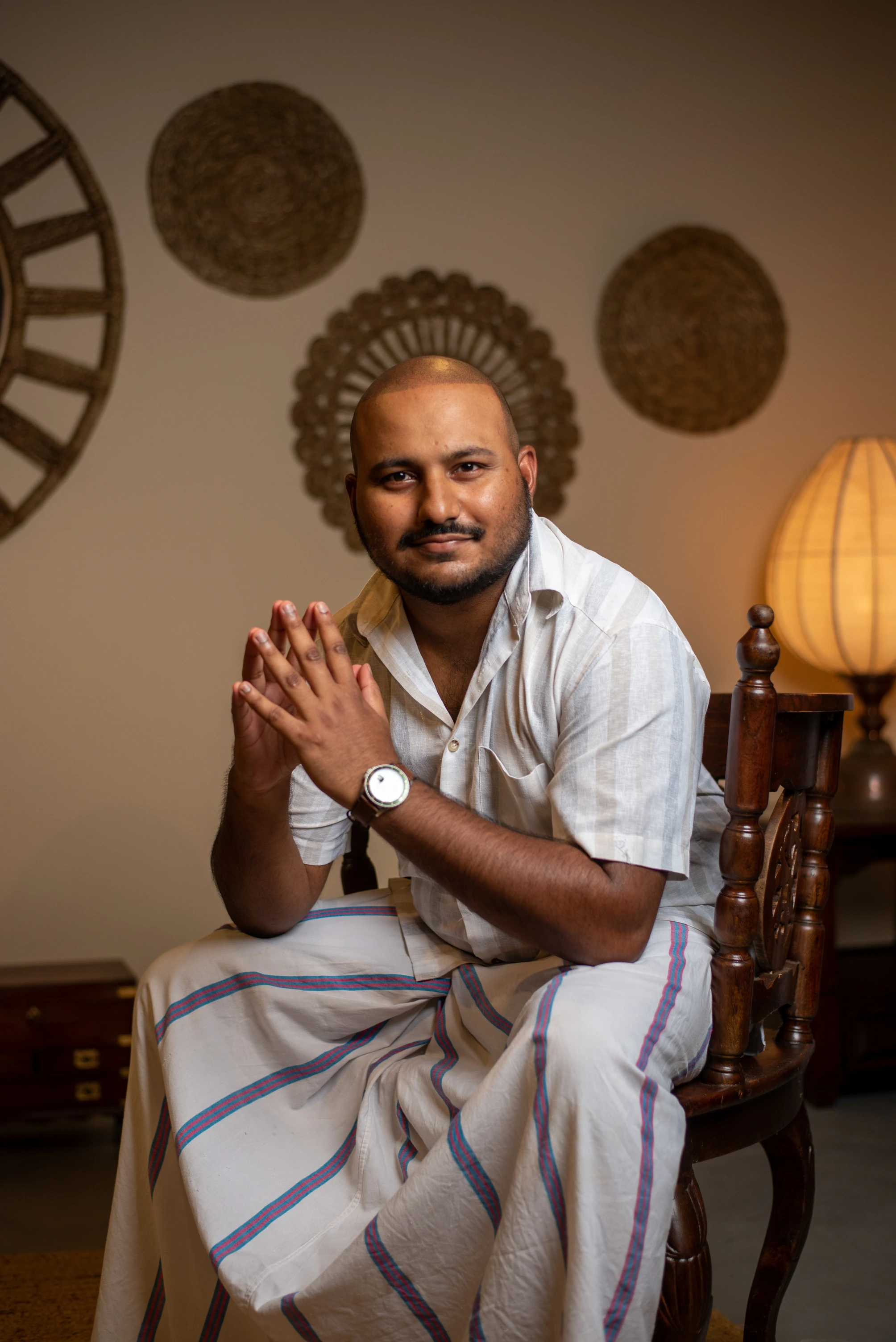 Full body portrait of a sitting villa owner in white clothes