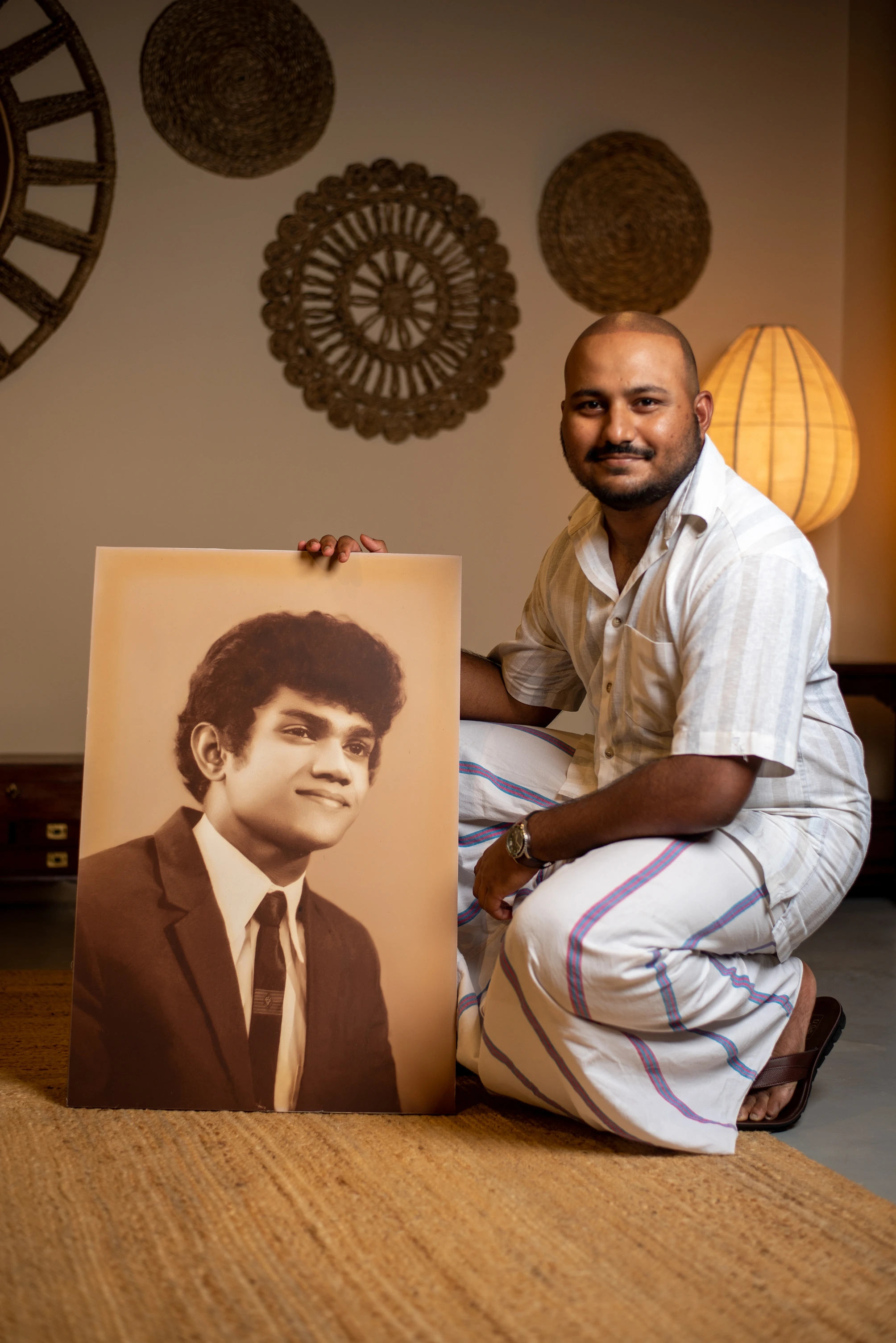 Villa owner AJ next to the portrait of his father Nelson Fernando